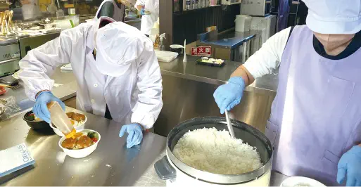 お弁当の調理作業をする利用者