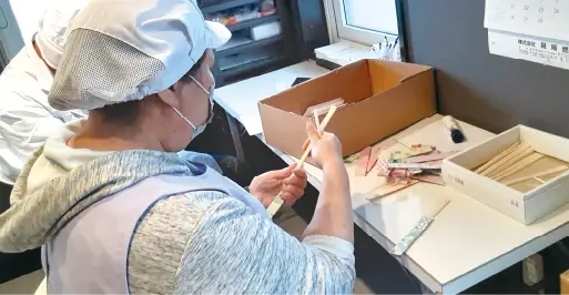 箸袋に箸を入れる作業をする利用者