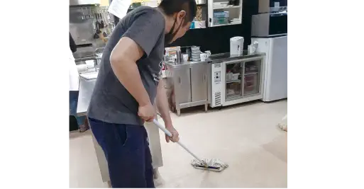 モップで床を清掃する利用者